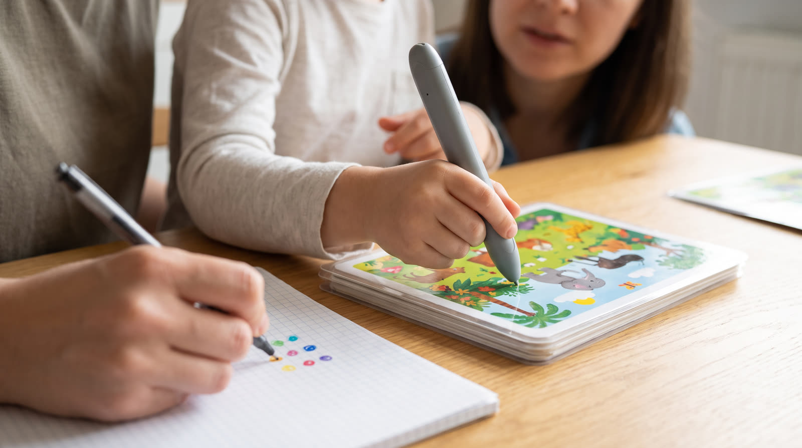 Child using an unbranded reading pen and illustrated learning materials for a touch book learning pen buyer guide